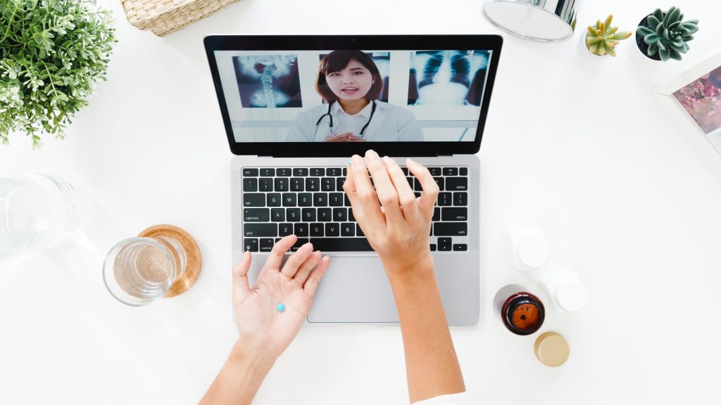 Young woman using computer for telehealth therapy session